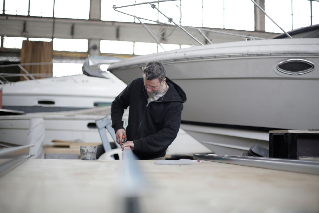 Agent SoVarNet effectuant le dégraissage mécanique du sol en résine d'un atelier maritime à La Seyne-sur-Mer